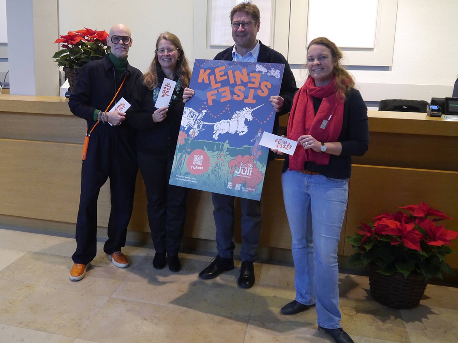 Vier Personen halten das Plakat für das Kleine Fest 2026