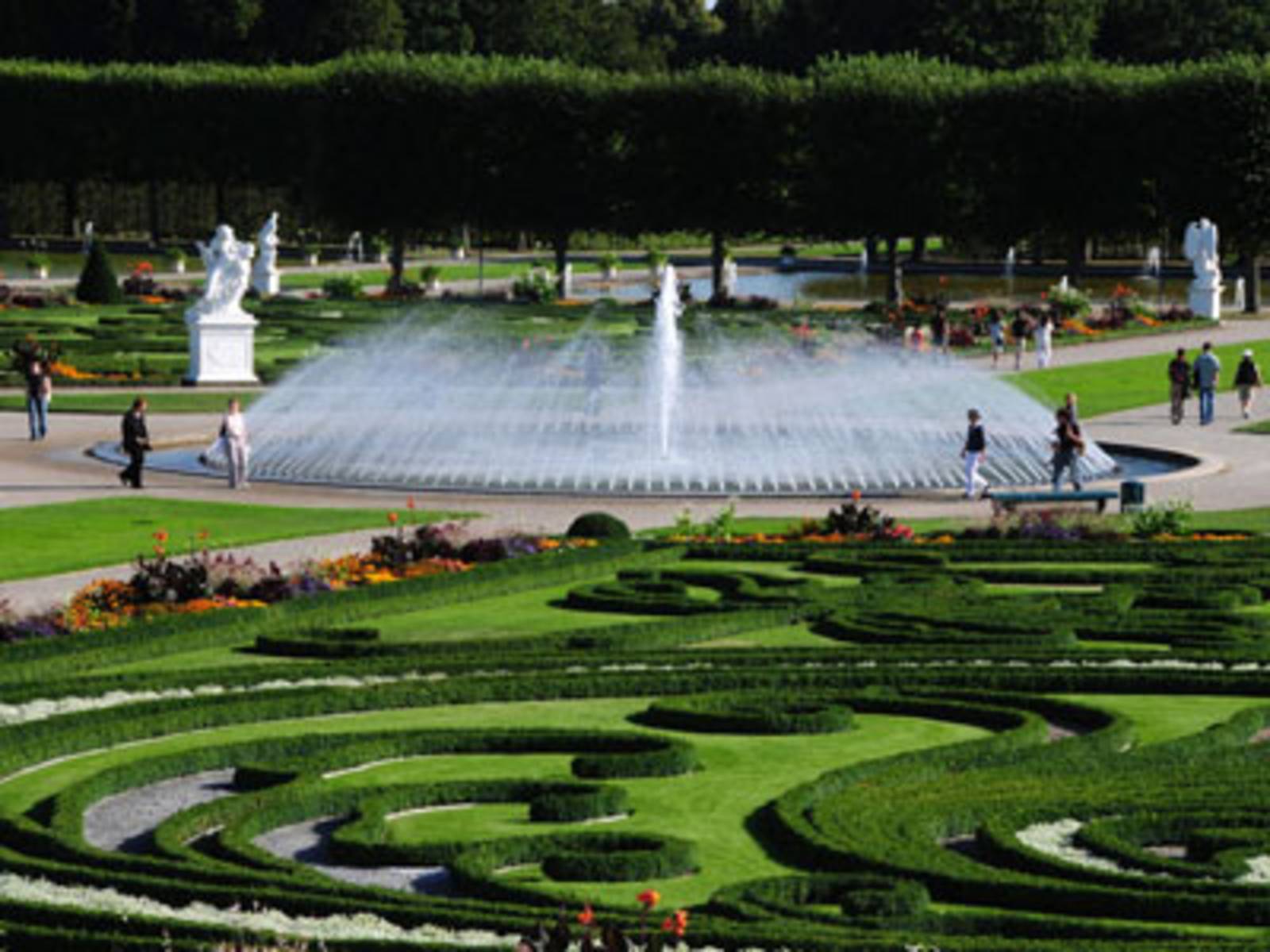 Ein Brunnen mit einer Glockenfontäne umgeben von einem Park