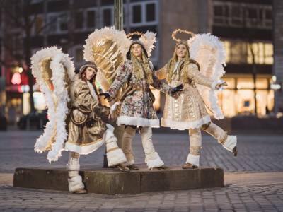 Drei als Engel verkleidete Menschen