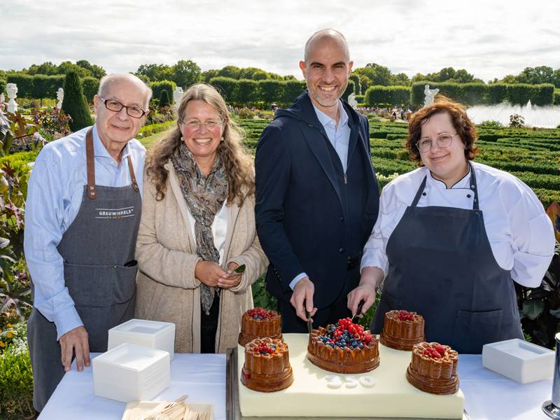 Vier Personen schneiden eine Torte an