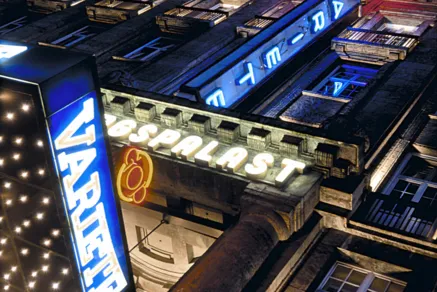 Beleuchtete Fassade des GOP Varieté-Theaters bei Nacht mit leuchtenden Schriftzügen und Neonlichtern an einem historischen Gebäude.