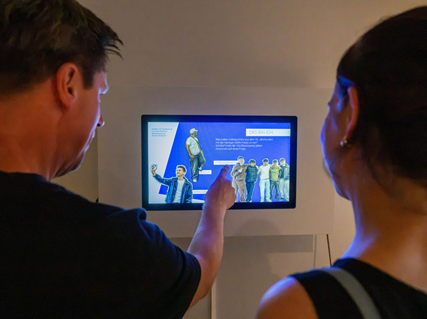 zwei Personen schauen auf die Inhalte der neuen Medienstation