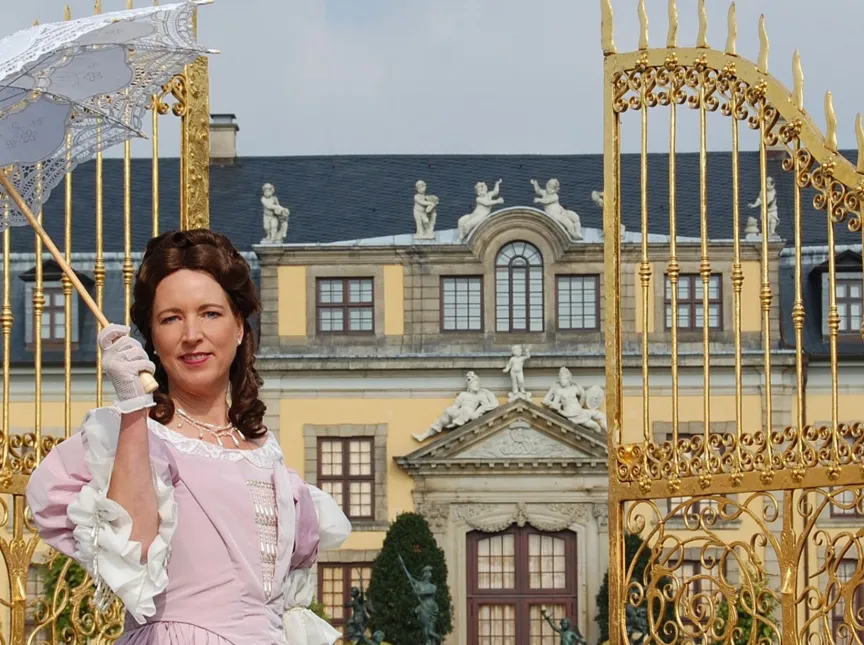 Eine Frau steht im Kostüm von Kurfürstin Sophie vor dem Goldenen Tor.
